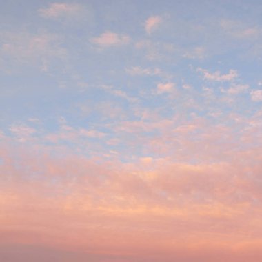 Parlayan pembe, altın rengi sirrus ve kümülüs bulutlarıyla açık mavi gökyüzü. Gün doğumu. Dramatik bulut manzarası. Sanat, meteoroloji, cennet, umut, barış, grafik kaynakları, resimli panoramik manzara