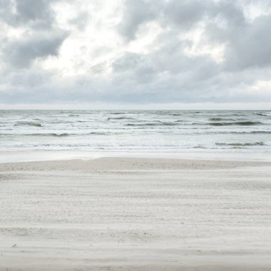 Baltık kıyıları (kum tepeleri) fırtınadan sonra gün batımında. Dramatik gökyüzü, parlayan bulutlar, rüzgar. Sonbahar manzarası. Doğa, çevre, ekoloji, kararsız hava, iklim değişikliği