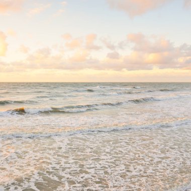 Deniz dalgaları ve sıçrama dokusu. Renkli gökyüzü suya yansıyor. Idyllic deniz manzarası. Kavramsal görüntü, uzun pozlama. Resimli bir manzara var. Arkaplan, duvar kağıdı, doğal desen, grafik kaynakları