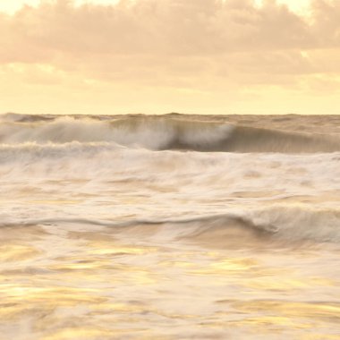 Deniz dalgaları ve sıçrama dokusu. Renkli gökyüzü suya yansıyor. Idyllic deniz manzarası. Kavramsal görüntü, uzun pozlama. Resimli bir manzara var. Arkaplan, duvar kağıdı, doğal desen, grafik kaynakları