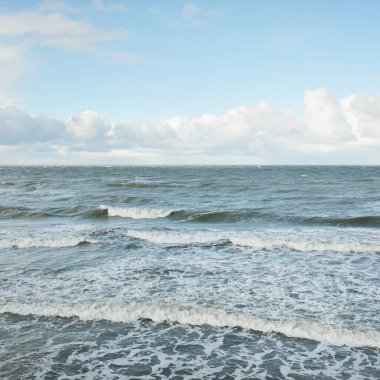 Fırtınadan sonra dramatik günbatımı bulutları altında Baltık Denizi. Dalgalar, su sıçratma. Destansı deniz manzarası. Kasırga, fırtına, sert hava, meteoroloji, ekoloji, iklim değişikliği, doğal olaylar
