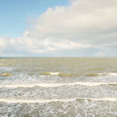 Fırtınadan sonra dramatik günbatımı bulutları altında Baltık Denizi. Dalgalar, su sıçratma. Destansı deniz manzarası. Kasırga, fırtına, sert hava, meteoroloji, ekoloji, iklim değişikliği, doğal olaylar