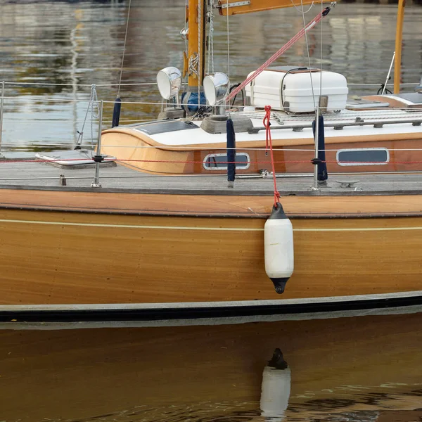 Modern klasik ahşap İsveçli yelkenli teknesi yat limanındaki bir iskeleye demirlemiş. Turizm, tatiller, boş zaman aktiviteleri, eğlence, yelkencilik temaları