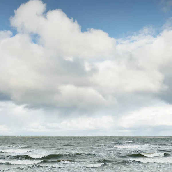Fırtınadan sonra dramatik günbatımı bulutları altında Baltık Denizi. Dalgalar, su sıçratma. Destansı deniz manzarası. Kasırga, fırtına, sert hava, meteoroloji, ekoloji, iklim değişikliği, doğal olaylar