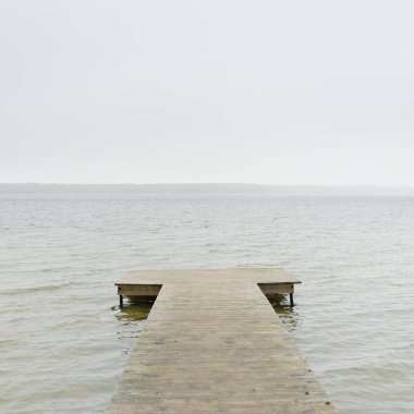 Yoğun bir siste orman nehri (göl). Ahşap iskele. Kasvetli gökyüzü, yağmur. Bulutlu bir gün. Idyllic manzara, kırsal manzara. Doğa, ekoloji, eko-turizm, yürüyüş, ekoloji beldesi, yerel turizm