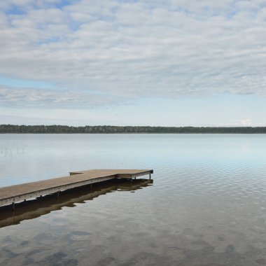 Orman nehri (göl) güneşli bir günde. Ahşap iskele. Clea gökyüzü, kristal berrak suda yansıyor. Idyllic manzara, kırsal manzara. Doğa, ekoloji, eko-turizm, yürüyüş, ekoloji beldesi, yerel turizm