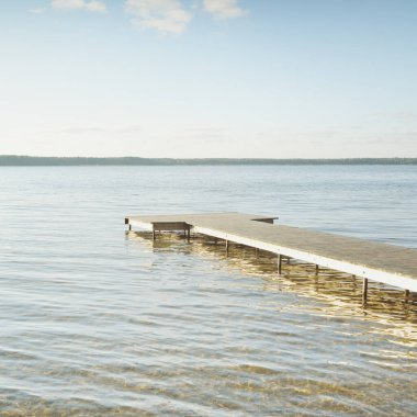 Orman nehri (göl) güneşli bir günde. Ahşap iskele. Clea gökyüzü, kristal berrak suda yansıyor. Idyllic manzara, kırsal manzara. Doğa, ekoloji, eko-turizm, yürüyüş, ekoloji beldesi, yerel turizm
