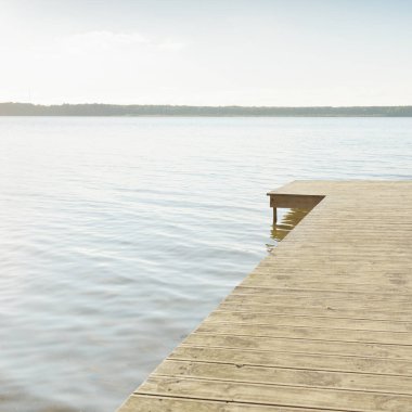 Orman nehri (göl) güneşli bir günde. Ahşap iskele. Clea gökyüzü, kristal berrak suda yansıyor. Idyllic manzara, kırsal manzara. Doğa, ekoloji, eko-turizm, yürüyüş, ekoloji beldesi, yerel turizm