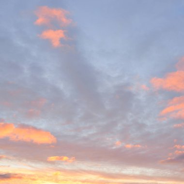 Parlayan pembe, altın rengi sirrus ve kümülüs bulutlarıyla açık mavi gökyüzü. Gün doğumu. Dramatik bulut manzarası. Sanat, meteoroloji, cennet, umut, barış, grafik kaynakları, resimli panoramik manzara