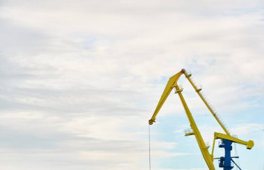 Letonya, Ventspils 'deki kargo terminali. Vinçler yakın plan. Baltık Denizi. Dramatik gün batımı gökyüzü. Yük taşımacılığı, lojistik, küresel iletişim, işletme, sanayi, arz, özel ekipman