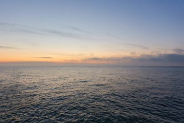 Gün batımında Baltık Denizi. Dramatik gökyüzü, mavi ve pembe parlayan bulutlar, yumuşak altın güneş ışığı, gece yarısı güneşi. Deniz manzarası, bulut manzarası, doğa. Panoramik görünüm