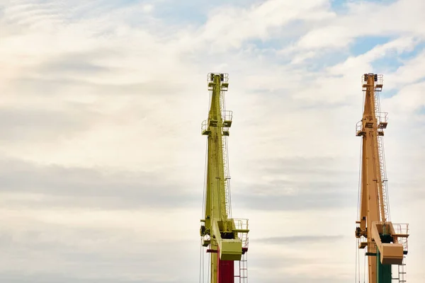 Cargo port terminal in Ventspils, Latvia. Cranes close-up. Baltic sea. Dramatic sunset sky. Freight transportation, logistics, global communications, business, industry, supply, special equipment