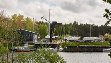 Zarif ve modern yelkenliler (kiralık ve satılık) bir rıhtıma demirlemiş ve yat limanında karada duruyor. Pavilosta, Letonya. Tamir ve hizmet, yaz tatili, gezi, boş zaman aktivitesi, spor