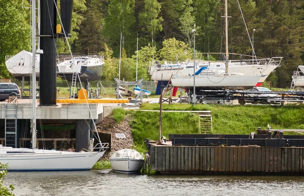Elegant and modern sailboats (for rent and sale) moored to a pier and standing on land in a yacht marina. Pavilosta, Latvia. Repair and service, summer vacations, cruise, leisure activity, sport