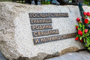 Eyalet sınırına adanmış taşın üzerinde bir yazı var. Rus sınır muhafızlarının anıtının bir parçası. Zafer Parkı. Galyano-Gorbunovsky massif. Nizhny Tagil. Sverdlovsk bölgesi. - Rusya. 08 Haziran 2021