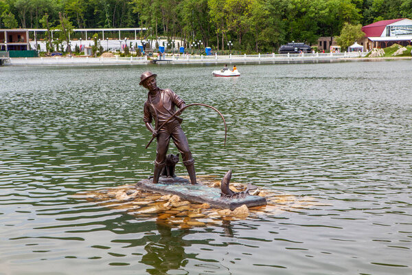The art object is the sculpture "The Fisherman and the Fisher Cat". Park lake. Zheleznovodsk. Stavropol region. Russia. May 23, 2021
