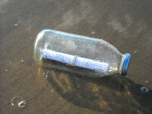 Потерянная записка в стеклянной бутылке на пляже.
