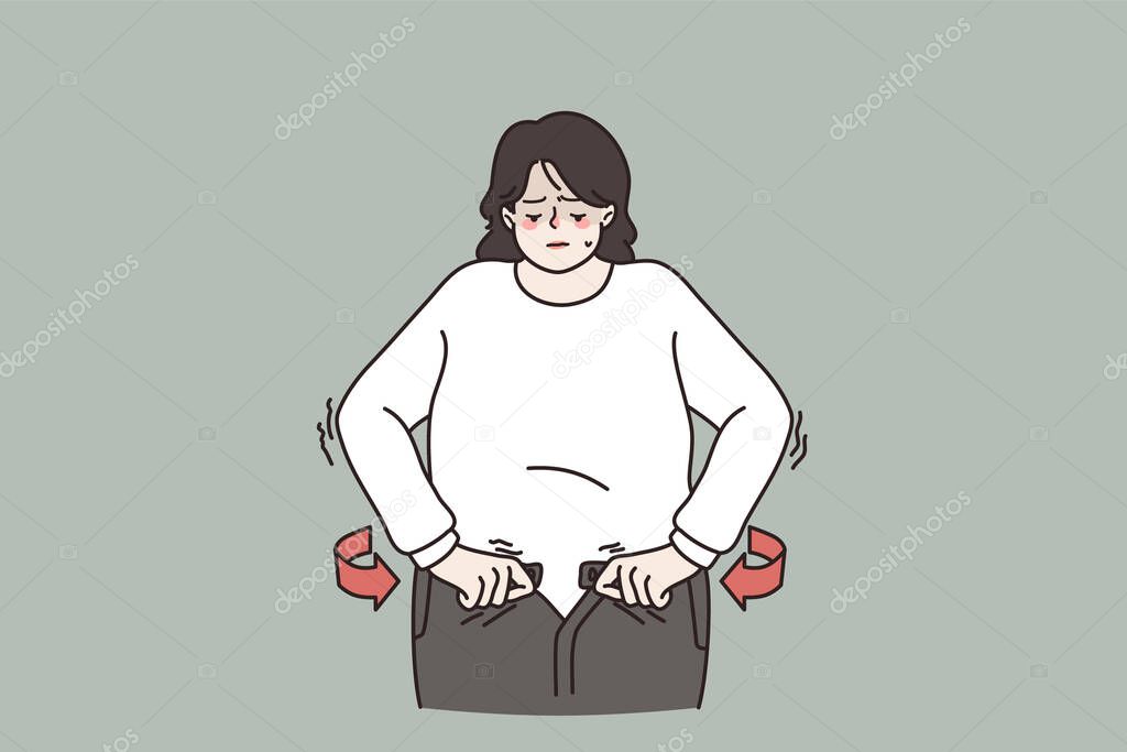 Overweight woman unable to fasten jeans belt 