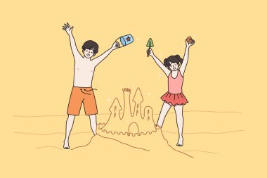 Mutlu çocuklar kumsalda kumla eğleniyor. 