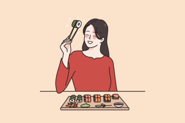 Japon restoranında suşi yiyen gülümseyen kadın. 