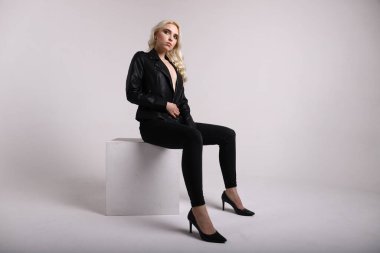 Beyaz arka planda deri ceketli bir kadın.