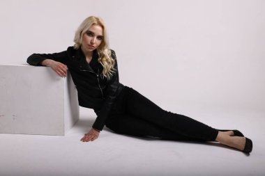 Beyaz arka planda deri ceketli bir kadın.