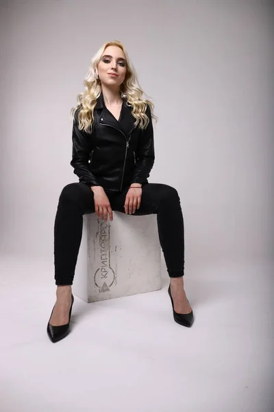 Beyaz arka planda deri ceketli bir kadın.