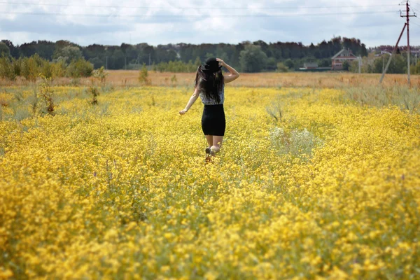 Girl running through flowers field — Stock Photo, Image