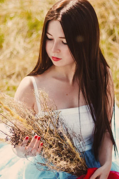 Bella ragazza bruna seduta in un campo di grano — Foto Stock