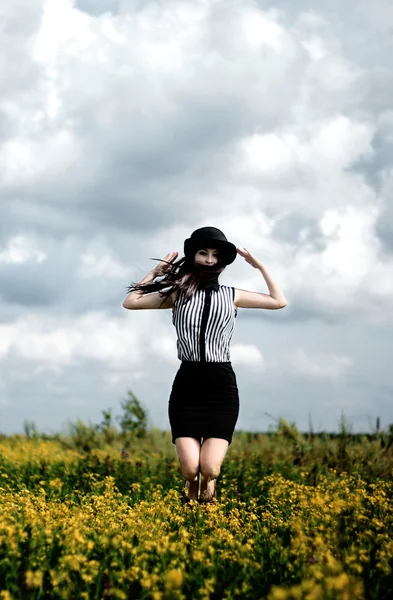 Girl in black hat jumping — Stock Photo, Image