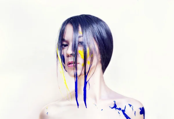 Rosto de beleza de uma menina pintada de azul e amarelo — Fotografia de Stock