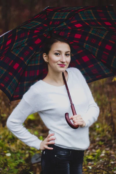 Chica en suéter blanco sonriendo con paraguas — Foto de Stock