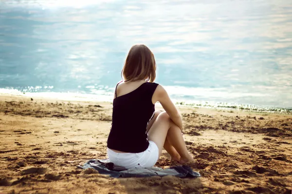 Fille seule se détendre sur la plage de la mer — Photo