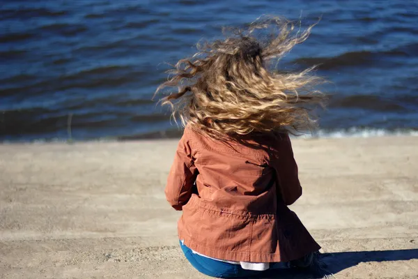 Mujer con pelo rubio rizado volador sobre fondo marino — Foto de Stock