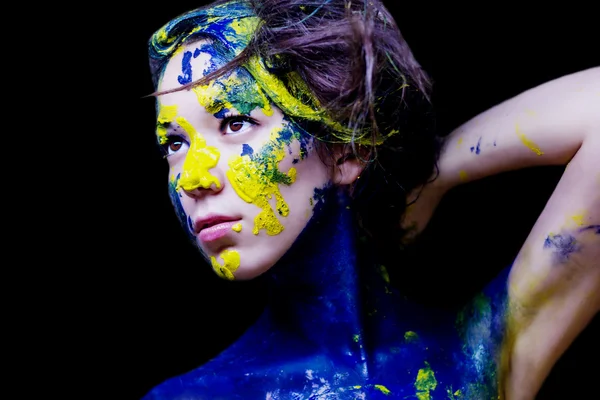 Retrato de moda de beleza de mulher pintada de azul e amarelo sobre fundo preto — Fotografia de Stock