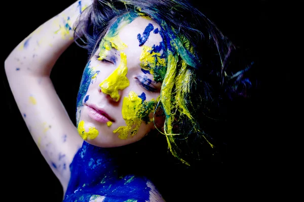 Retrato de moda de belleza de mujer pintada de azul y amarillo sobre fondo negro — Foto de Stock