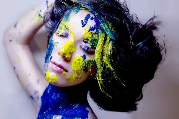 Retrato de moda de beleza de mulher pintada de azul e amarelo sobre fundo preto — Fotografia de Stock