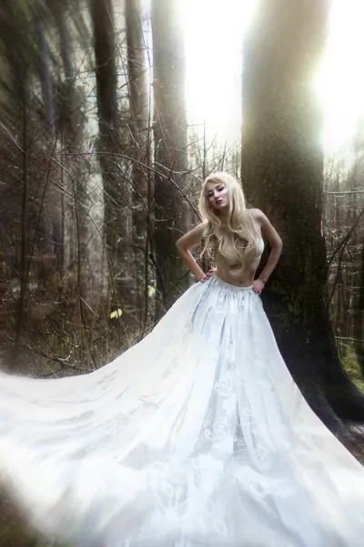 Πανέμορφη γυναίκα σε μακριές άσπρες φούστα στο παραμύθι δάσος ηλιόλουστη — Φωτογραφία Αρχείου