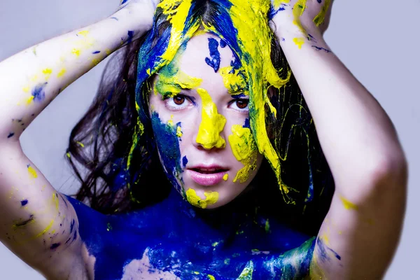Krása módní zblízka portrét ženy namalovaný modré a žluté na bílém pozadí Stock Snímky