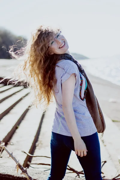 Happy woman with glasses and curly hair on bright sunny background — Stock Photo, Image