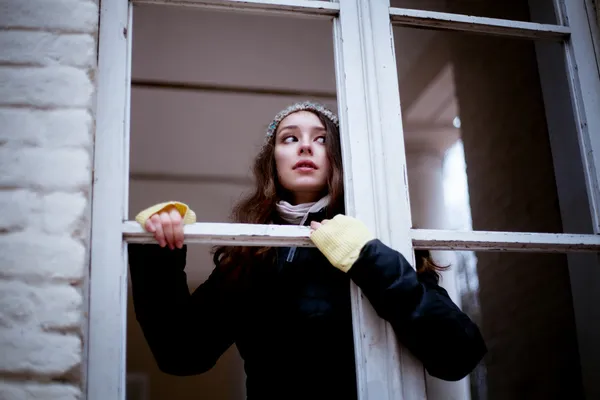 Vrouw op zoek door het raam en uit angst voor iets — Stockfoto