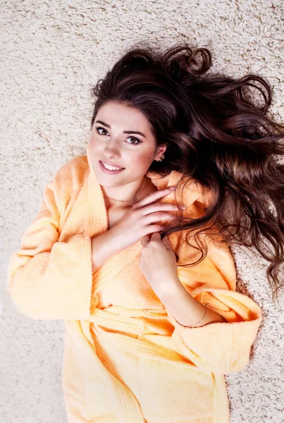 Beautiful woman in orange robe with beautiful brunette hair — Stock Photo, Image