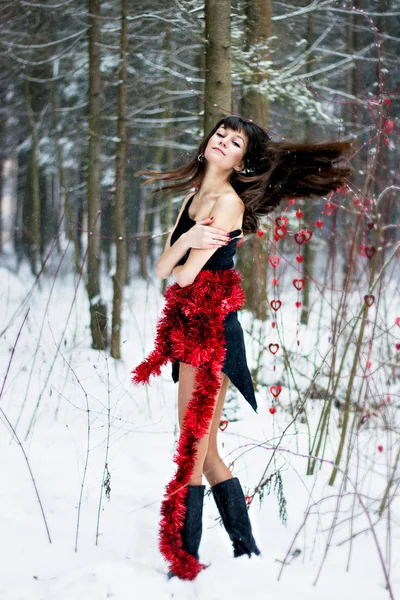 Mooie vrouw met heldere klatergoud in winter forest — Stockfoto