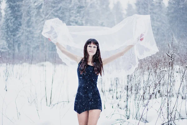 Pięknej narzeczonej pod zasłoną na tle białego śniegu — Zdjęcie stockowe