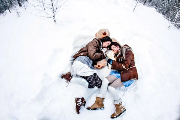 Mujeres de moda acostadas sobre nieve blanca fondo de invierno ojo de pez —  Fotos de Stock