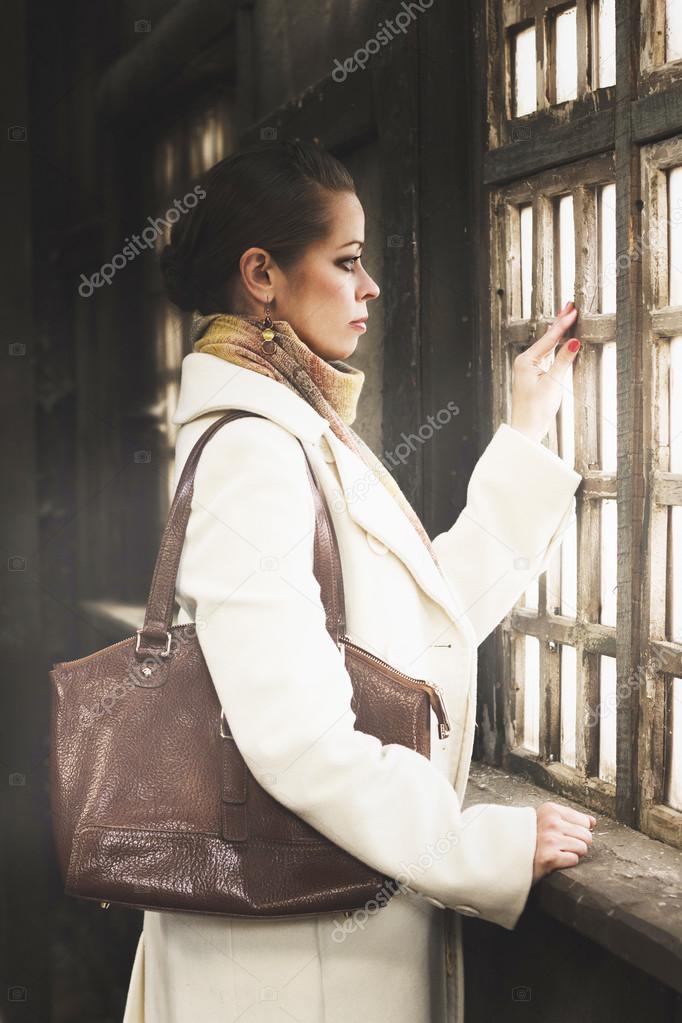 Romantic fashion portrait of a beautiful woman looking out the window