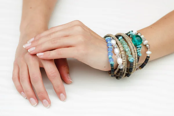 Bracelets on a beautiful woman's hands with manicure — Stock Photo, Image