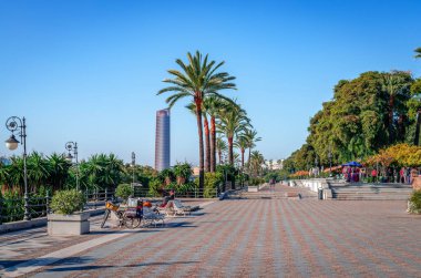 Seville, Spain - December 23 2014: View of Paseo Alcalde Marques del Contadero that runs parallel to the Canal de Alfonso XIII, of river Guadalquivir. Sevilla Tower is in the background.