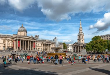 Londra, İngiltere - 15 Eylül 2018: Trafalgar Meydanı 'nda sonbaharda güneşli bir öğleden sonra turistler. Arka planda Ulusal Galeri ve St. Martin-in-the-Fields kilisesi var..