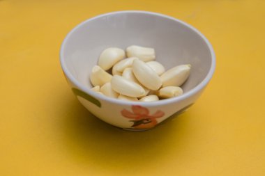 bir kase sarı backgroud sarımsak taze kabuğu